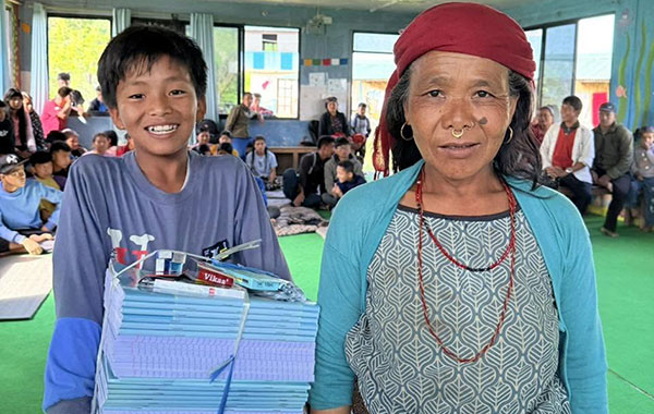 photo of mother and son receiving text books